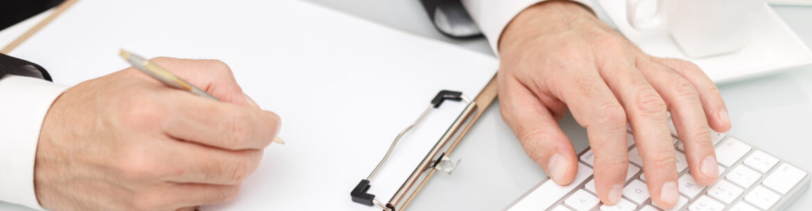 Male hands using modern computer and writing with pen business concept